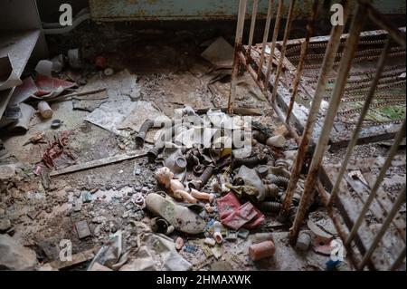 Spielzeug, Puppen, Schuhe und Möbel in verschiedenen Zerfallszuständen in einem verlassenen Kindergarten in Pripyat, Ukraine, in der Nähe des Kernkraftwerks Tschernobyl. Stockfoto