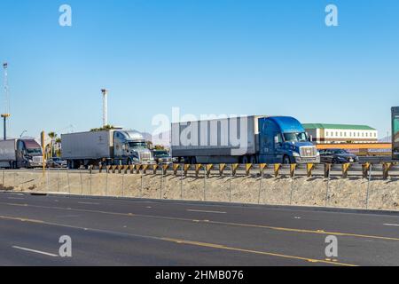 Victorville, CA, USA – 7. Februar 2022: Sattelschlepper stecken auf der südwärts verfolgenden Interstate 15 in Victorville, Kalifornien, im Verkehr fest. Stockfoto