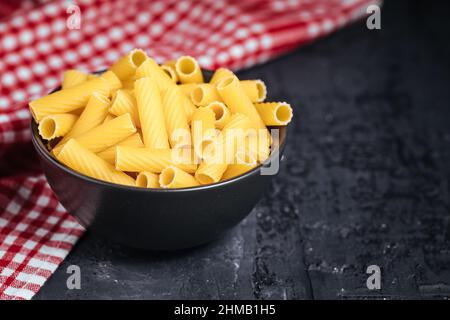 Verschiedene Auswahl von rohen Vergangenheit wie Fusili, Tagliatella und Macaronis auf dunklem Hintergrund. Stockfoto