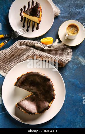 Schmackhafter baskischer gebrannter Käsekuchen mit Kaffee auf farbigem Hintergrund Stockfoto