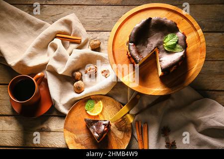 Schmackhafter baskischer gebrannter Käsekuchen mit Kaffee auf Holzgrund Stockfoto