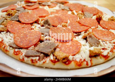 Nahaufnahme einer Perfect Raw Meat Lovers Pizza Ready for the Oven Stockfoto