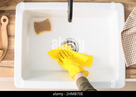 Frau wischte Keramikwaschbecken, Nahaufnahme Stockfoto
