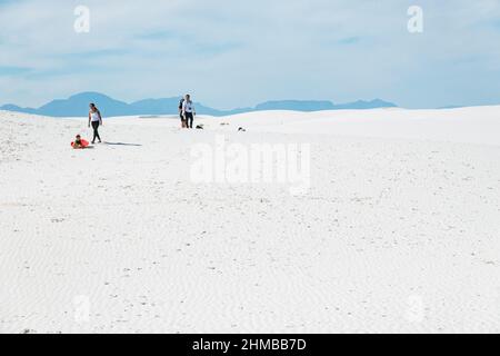 Eine Familie spielt in den Sanddünen des White Sands National Park, New Mexico, USA Stockfoto