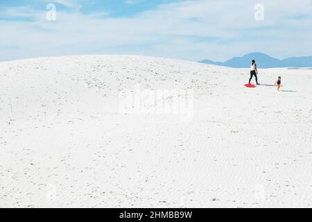 Eine Familie spielt in den Sanddünen des White Sands National Park, New Mexico, USA Stockfoto