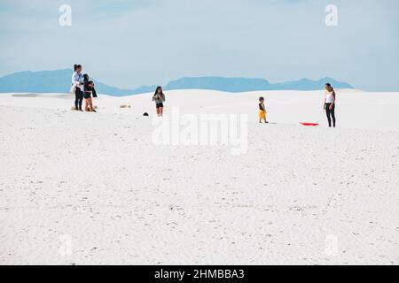 Eine Familie spielt in den Sanddünen des White Sands National Park, New Mexico, USA Stockfoto