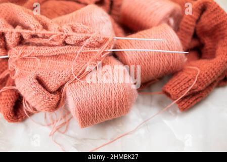 Kugeln aus Fadenwolle mit Stricknadeln Stockfoto