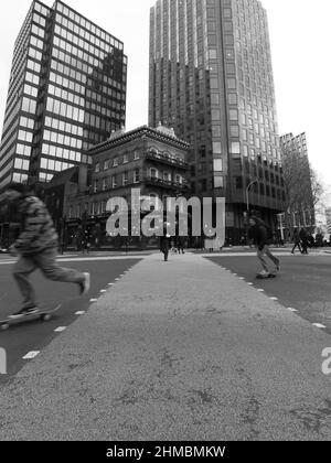 London, Greater London, England, Februar 05 2022: Skateboarder an einer Kreuzung vor dem Albert Pub in der Victoria Street in Schwarzweiß. Stockfoto