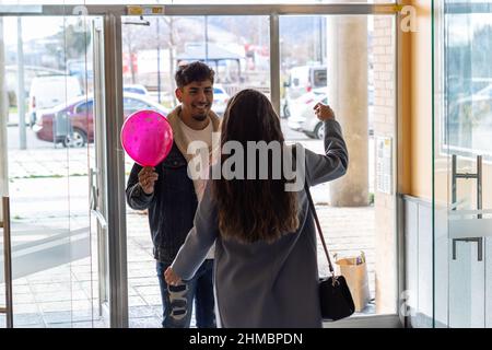Eine junge Frau umarmte ihren lateinischen Freund und dankte ihm für die Überraschung zum Valentinstag Stockfoto