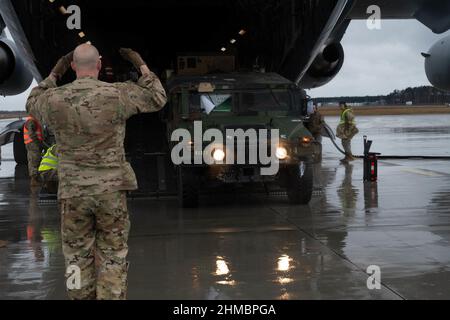 Jasionka, Polen. 08th. Februar 2022. Ein US Air Force Airman marschiert am 7. Februar aus einem C-17 Globemaster III-Flugzeug, das dem 62nd Airlift Wing von der Joint Base Lewis-McChord, Washington, auf dem Rzeszów-Jasionka Airport, Polen, zugewiesen wurde, einen US Army Humvee. 2022. US-Personal und Ausrüstung kamen, um die NATO-Alliierten und -Partner zu unterstützen, um eine kollektive Bereitschaft, Interoperabilität und Beziehungen zu verbessern. Foto von Senior Airman Taylor Slater/USA Air Force/UPI Credit: UPI/Alamy Live News Stockfoto