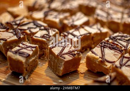 Zuckerhaltiges Erdnussbutter-Fudge wird für die Weihnachtsbecher in Stücke geschnitten Stockfoto