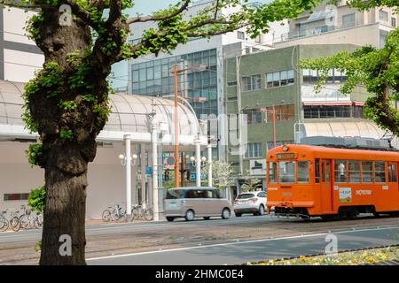 Matsuyama, Japan - 22. April 2019 : Lokale Straßenbahn und Stadtstraße Stockfoto