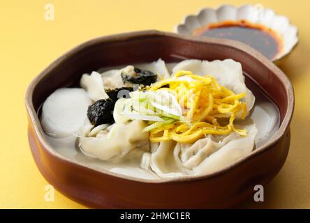 Traditionelle koreanische Küche Aufgeschnittene Reiskuchensuppe, Tteok- und Mandu-Dumpling-Suppe, Nahaufnahme Stockfoto