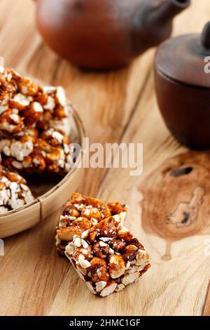 Brondong Jagd oder Bororndong, javanesischer traditioneller Snack Süßer Popcorn mit klebriger Palmzucker. Serviert mit Tee Stockfoto