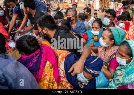 Die armen Menschen kämpfen darum, die Nahrungsmittel zu erhalten, die eine kleine lokale Organisation auf den Straßen von Dhaka verteilt.85 % der wirtschaftlich aktiven Bevölkerung des Landes sind im informellen Sektor ohne jegliche soziale Sicherheit beschäftigt, Dieser Sektor war aufgrund der Schließung vieler Aktivitäten und der limitierten Bewegungen der am stärksten von der Pandemie geschädigte Sektor. Stockfoto