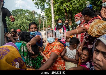 Dhaka, Bangladesch. 07th. Mai 2021. Arme Menschen kämpfen darum, Nahrungsmittelhilfe zu erhalten, die eine kleine lokale Organisation auf den Straßen von Dhaka verteilt. 85 % der wirtschaftlich aktiven Bevölkerung des Landes sind im informellen Sektor ohne jede Art von sozialer Sicherheit beschäftigt. Dieser Sektor war aufgrund der Schließung vieler Aktivitäten und der limitierten Bewegungen der am stärksten von der Pandemie geschädigte Sektor. (Foto von Israel Fuguemann/SOPA Images/Sipa USA) Quelle: SIPA USA/Alamy Live News Stockfoto