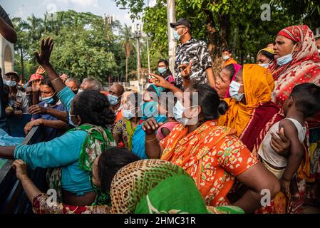 Dhaka, Bangladesch. 07th. Mai 2021. Die armen Menschen kämpfen darum, die Nahrungsmittel zu erhalten, die eine kleine lokale Organisation auf den Straßen von Dhaka verteilt.85 % der wirtschaftlich aktiven Bevölkerung des Landes sind im informellen Sektor ohne jegliche soziale Sicherheit beschäftigt, Dieser Sektor war aufgrund der Schließung vieler Aktivitäten und der limitierten Bewegungen der am stärksten von der Pandemie geschädigte Sektor. (Foto von Israel Fuguemann/SOPA Images/Sipa USA) Quelle: SIPA USA/Alamy Live News Stockfoto