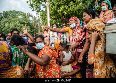 Dhaka, Bangladesch. 7th. Mai 2021. Die armen Menschen kämpfen darum, die Nahrungsmittel zu erhalten, die eine kleine lokale Organisation auf den Straßen von Dhaka verteilt.85 % der wirtschaftlich aktiven Bevölkerung des Landes sind im informellen Sektor ohne jegliche soziale Sicherheit beschäftigt, Dieser Sektor war aufgrund der Schließung vieler Aktivitäten und der limitierten Bewegungen der am stärksten von der Pandemie geschädigte Sektor. (Bild: © Israel Fuguemann/SOPA Images via ZUMA Press Wire) Stockfoto