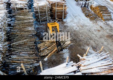 Der Lader lädt die Protokolle in der werkseitigen Draufsicht. Stockfoto