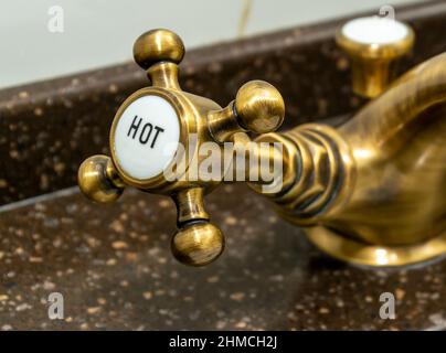 Kupferhahn in der Hoteldusche, konzentrieren Sie sich auf Heißwasserhahn Stockfoto