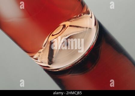 Vorderansicht Nahaufnahme einer Roséweinflasche Punt mit Reflexion auf glänzender Oberfläche Stockfoto