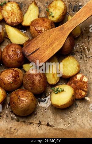 Würzige Bratkartoffel in Schale mit Rosmarin und Knoblauch auf Pergamentschicht Stockfoto