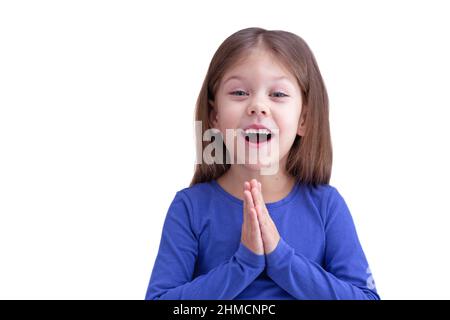 Happy Pending Wunder Kind Kind hält Gebetshände isoliert auf weißem Hintergrund, Blick auf Kamera Taille bis kaukasischen kleinen Mädchen von 5 Jahren in blau Stockfoto