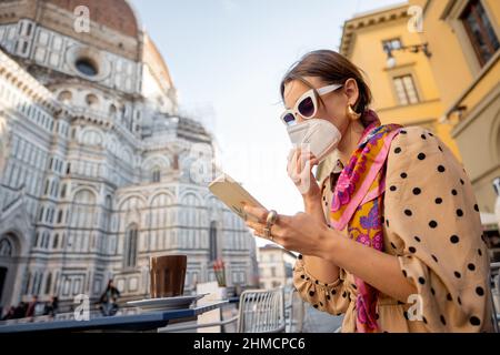Frau in medizinischer Maske im Café in der Nähe der Kathedrale von Florenz Stockfoto