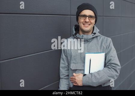 Nahaufnahme Porträt eines hübschen 30-35 Jahre alten Mannes im Freien, der in der Nähe der Wand steht Stockfoto