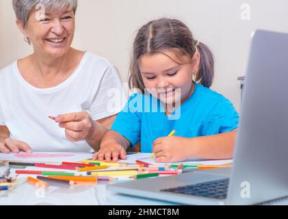 Großmutter und Kind lernen online miteinander zu zeichnen. Malerei für Kinder und Senioren Stockfoto