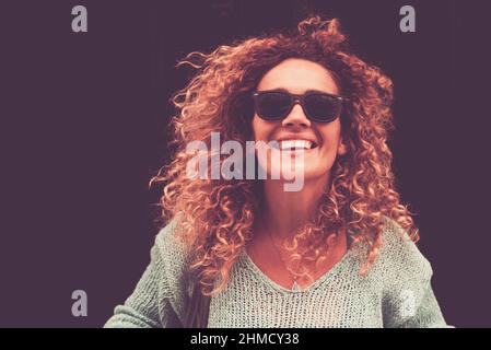Glücklich fröhlich attraktive junge Erwachsene Frau Porträt mit schwarzem Hintergrund für Kopieplatz. Weibliche Menschen mittleren Alters lächeln und lachen eine lor. Braun Stockfoto
