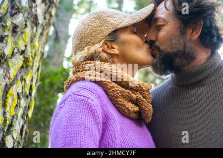 Liebe und Beziehung Erwachsene Paar Mann und Frau küssen im Freien. Menschen zusammen in romantischer Szene mit Wald im Freien Park im Hintergrund. Romantik l Stockfoto