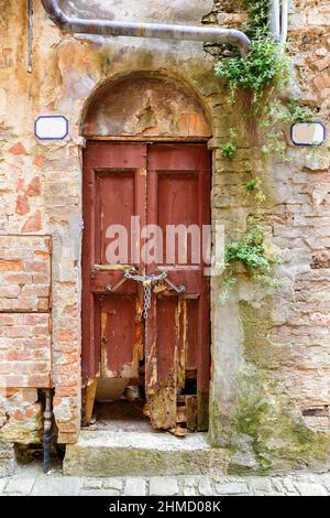 Alte kaputte Tür, die mit einer Kette an einer Straße verschlossen war Stockfoto