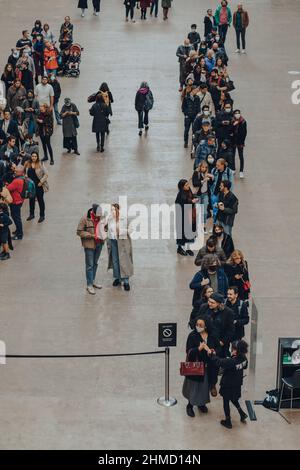 London, Großbritannien - 23,2021. Oktober: Menschen stehen in der Turbine Hall an, um QR-Codes zu scannen, die für den Eintritt in das Londoner Museum Tate Modern benötigt werden Stockfoto