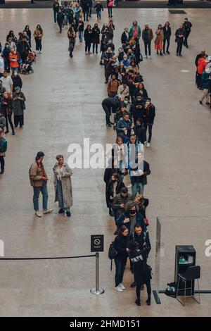London, Großbritannien - 23,2021. Oktober: Menschen stehen in der Turbine Hall an, um QR-Codes zu scannen, die für den Eintritt in das Londoner Museum Tate Modern benötigt werden Stockfoto