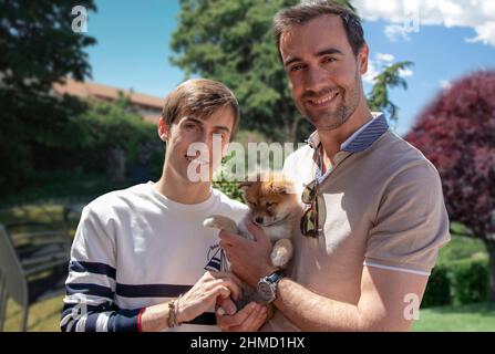 Zwei junge Männer, schwules Paar mit ihrem Welpen, shiba Inu Hund - Outdoor Stockfoto