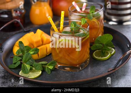 Mango Eistee mit Limette und Minze. Erfrischendes Bio-Erfrischungsgetränk Stockfoto