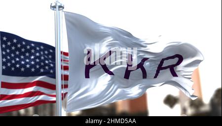 New York, USA, November 2021: Die im Wind winkende Flagge mit dem KKR-Logo und die amerikanische Nationalflagge im Hintergrund Stockfoto