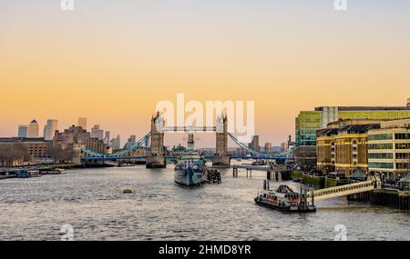 Tower Bridge, London, bei Sonnenuntergang mit Canary Wharf im Hintergrund. Stockfoto