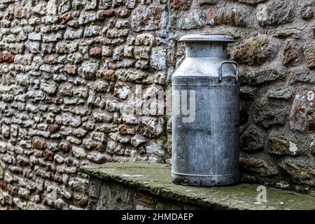 Milch wird an einer Steinmauer abgelassen Stockfoto