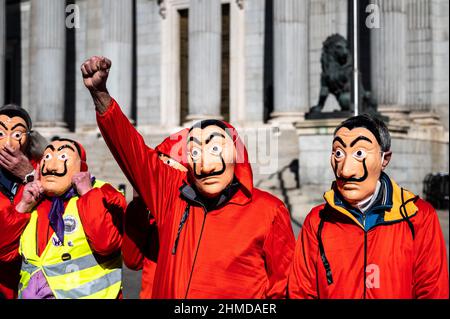 Madrid, Spanien. 09th. Februar 2022. Rentner in roten Anzügen und Dali-Masken der spanischen Netflix-Serie La Casa de Papel (Money Heist) werden während eines Protestes des Abgeordnetenkongresses an die Bank von Spanien gesehen, um bessere Renten zu fordern. Quelle: Marcos del Mazo/Alamy Live News Stockfoto