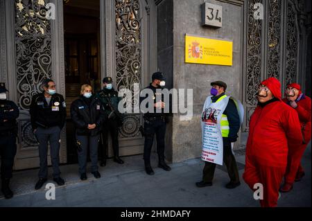 Madrid, Spanien. 09th. Februar 2022. Rentner, einige in roten Anzügen und Dali-Masken der spanischen Netflix-Serie La Casa de Papel (Money Heist), werden während eines Protestes des Abgeordnetenkongresses an die Bank von Spanien gesehen, um bessere Renten zu fordern. Quelle: Marcos del Mazo/Alamy Live News Stockfoto