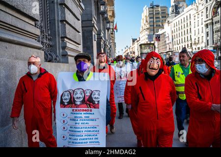 Madrid, Spanien. 09th. Februar 2022. Rentner, einige in roten Anzügen und Dali-Masken der spanischen Netflix-Serie La Casa de Papel (Money Heist), werden während eines Protestes des Abgeordnetenkongresses an die Bank von Spanien gesehen, um bessere Renten zu fordern. Quelle: Marcos del Mazo/Alamy Live News Stockfoto