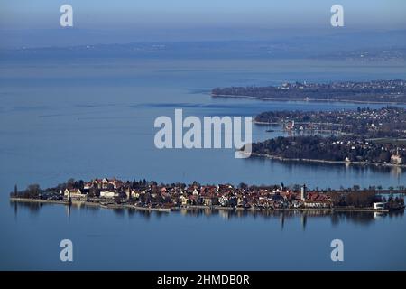 Bregenz, Österreich. 09th. Februar 2022. Die Insel Lindau im Bodensee (vorne) ist vom Pfänder in Vorarlberg in Österreich aus zu sehen. Im Hintergrund sind die Gemeinden Wasserburg und Langenargen zu sehen. Am Horizont ist die rund 46 Kilometer entfernte Stadt Konstanz noch im Dunst zu sehen. Quelle: Felix Kästle/dpa/Alamy Live News Stockfoto