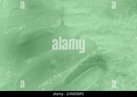 Flüssiges grünes Balsam mit verschmiertem Gewebe. Das Konzept der Naturkosmetik. Selbstgemachte Bienenwachs-Probe. Aloe Vera kosmetische Gel Textur Hintergrund. Hautpflege Stockfoto