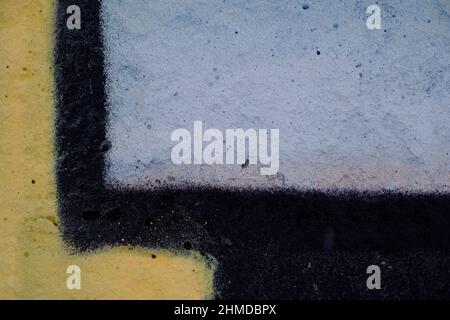 Alte schwarz-gelbe Farbe mit Rissen an der Ziegelwand als Hintergrund, Textur, selektiver Fokus Stockfoto