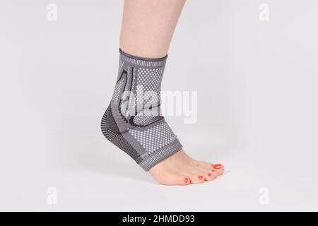 Orthopädische Knöchelstütze. Medizinische Knöchelbandage. Medizinische Knöchelstützband Verstellbare Wickelbandage Brace Fuß Schmerzlinderung Sport. Beinstrebe isoliert ein Stockfoto