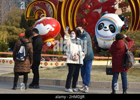 Peking, China - 09. Februar 2022, Peking, China. 09th. Februar 2022. Touristen posieren für ein Foto mit dem Maskottchen der Olympischen Winterspiele bing Dwen Dwen und der Shuey Rhon Rhon der Winter-Paralympics im Hintergrund.die Olympischen Winterspiele 24th wurden in Peking, China, eröffnet. Peking ist die einzige Stadt der Welt, in der sowohl die Olympischen Sommerspiele als auch die Olympischen Winterspiele ausgetragen wurden. Kredit: SOPA Images Limited/Alamy Live Nachrichten Stockfoto