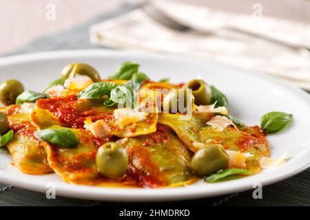Ravioli-Pasta mit Tomatensauce, Oliven und Basilikum Stockfoto