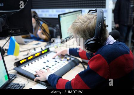 Toningenieur, der während des Radiomarathons bis zum Radio Day den Schallpegel mit einem Tonmischer im Studio reguliert. 3. Januar 2019. Kiew, Ukraine Stockfoto